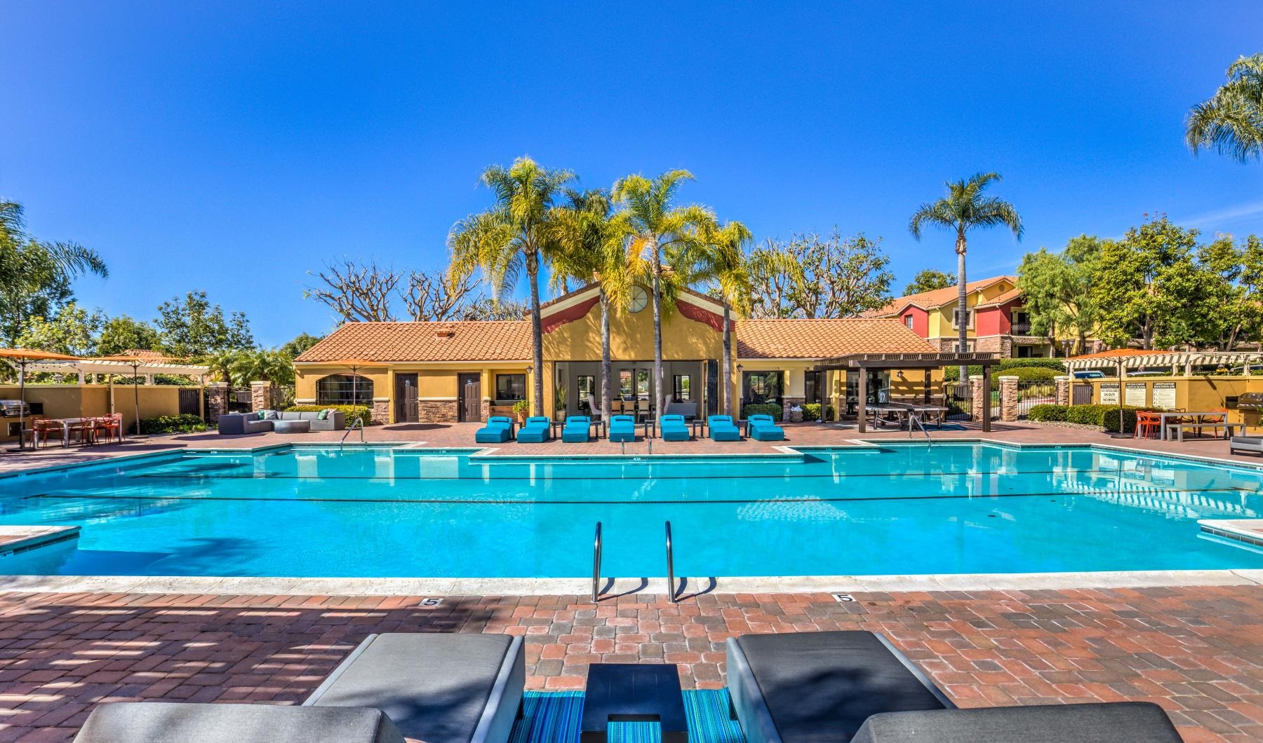 Swimming pool with loungers in front of the community center at Overlook at Bernardo Heights, the best apartments in San Diego